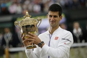 Serbia's Novak Djokovic holds the winner's trophy after beating Switzerland's Roger Federer in the men's singles final match, during the presentation on day thirteen of the 2015 Wimbledon Championships at The All England Tennis Club in Wimbledon, southwest London, on July 12, 2015. Djokovic won the match 7-6, 6-7, 6-4, 6-3.  RESTRICTED TO EDITORIAL USE  --  AFP PHOTO / ADRIAN DENNIS        (Photo credit should read ADRIAN DENNIS/AFP/Getty Images)