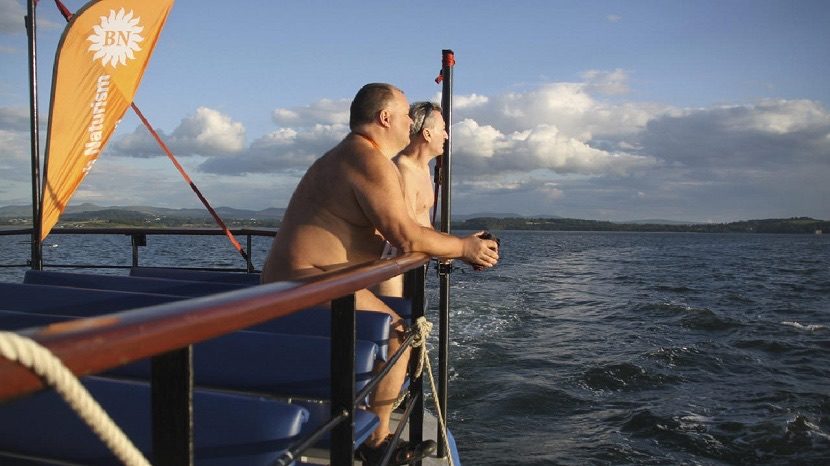 Members of British Naturism enjoy a sunny evening cruise to celebrate the organisations 50th anniversary on the Firth of Forth Scotland UK 5 July 2014.